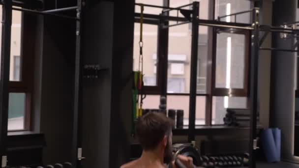 特写后视拍摄成人肌肉运动男子蹲下与壶铃在室内在健身房 — 图库视频影像