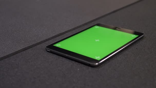 Closeup shoot of the tablet with green chroma screen with application for work out tracking lying on the floor in the gym — Stock Video