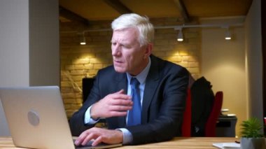 İşyerinde ki ofiste dizüstü bilgisayar öksürme ve hasta olma ile eski beyaz işadamının yakın çekim çekimi