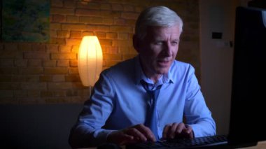 Eski kafkas işadamının video oyunları oynayıp, ışıklar kapalı dairede mutlu olmayı kazanan yakın çekim portresi