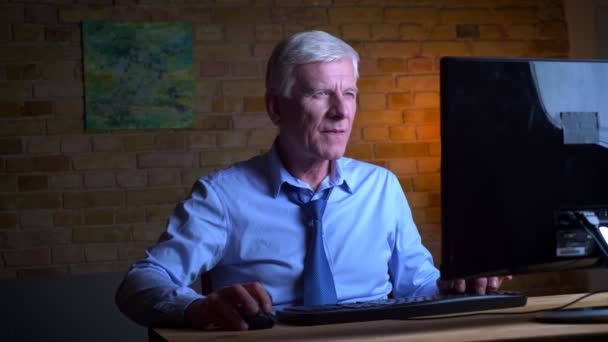 Closeup portrait of old caucasian businessman playing video games on the computer failing and being frustrated indoors in the apartment with lights off — Stock Video