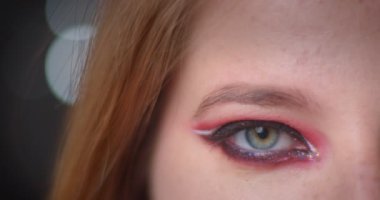 Bulanık ışıklar bokeh arka plan üzerinde parlak makyaj ile sarışın modelin yakın çekim yarım yüz çekimi.