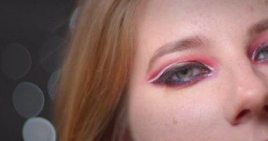 Bokeh arka planda kamera ile baştan çıkarıcı flört parlak makyaj ile sarışın modelin yarım yüz portre.