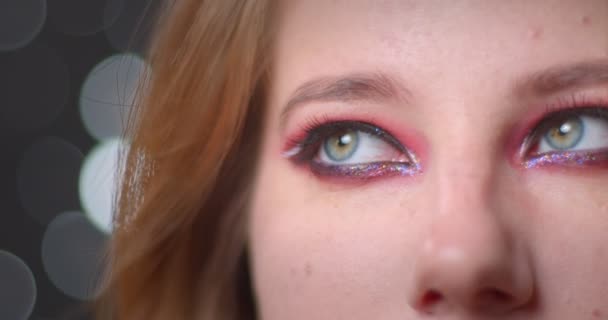 Potret cantik pirang model dengan make-up cerah menonton ke atas yang bermimpi pada bokeh latar belakang . — Stok Video