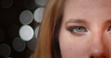 Bulanık ışıklar bokeh arka plan üzerinde olağanüstü koyu ve parlak makyaj ile sarışın modelin yarım yüz ateş.