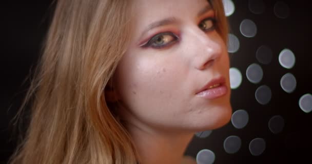 Profil pemotretan model jahe dengan make-up dingin menonton dengan senyum menggoda ke kamera di latar belakang bokeh . — Stok Video