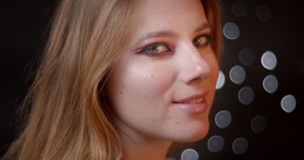 Atractivo modelo de jengibre con maquillaje brillante y vívido coqueteando con la cámara siendo seductor sobre fondo bokeh . — Vídeo de stock