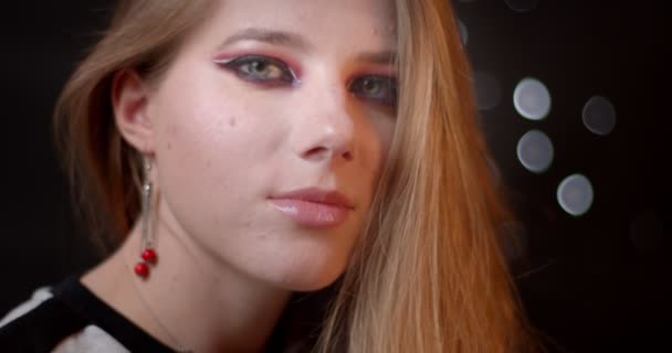 Sexy gember model met heldere en levendige make-up flirten met camera wordt verleidelijk op bokeh achtergrond. — Stockvideo