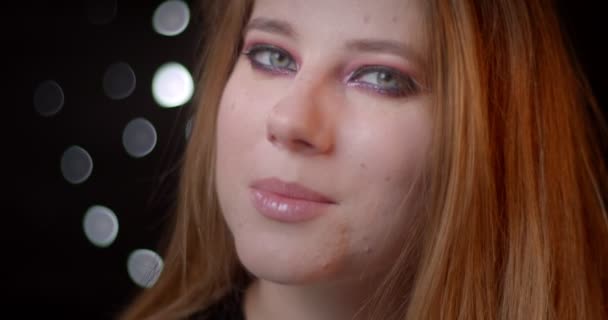 Portrait de jolie mannequin blonde avec maquillage lumineux regardant vers le haut étant rêveuse et mystérieuse sur fond bokeh . — Video