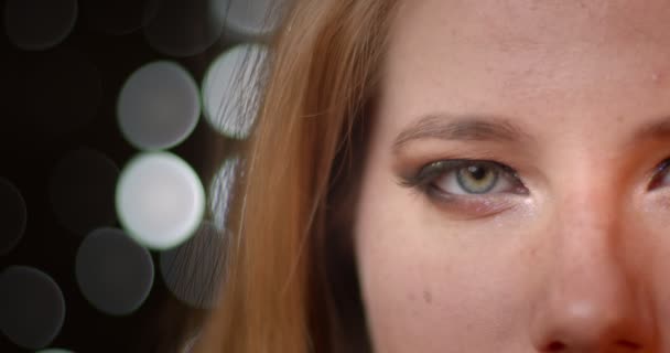 Sesión de media cara de modelo rubio con extraordinario maquillaje oscuro y brillante sobre luces borrosas fondo bokeh . — Vídeo de stock