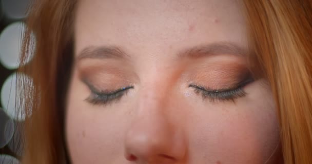 Krásný model s třpytících se make-up záhadně v kameře na rozmazaných světlech pozadí. — Stock video