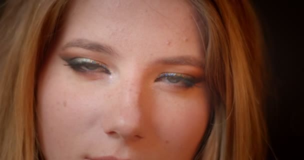 Joli modèle avec des montres de maquillage chatoyantes gracieusement dans la caméra sur fond de bokeh lumières floues . — Video