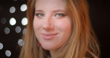 Bokeh arka planda mutlu bir gülümseme ile kameraya glitter koyu makyaj saatler ile Blonde modeli.