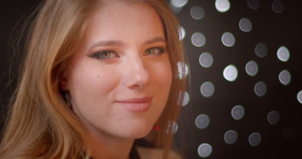 Profilshooting des blonden Models mit Glitzer-Make-up lächelt glücklich in die Kamera auf Bokeh-Hintergrund. — Stockvideo