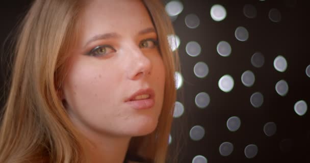 Profilshooting des blonden Models mit Glitzer-Make-up lächelt glücklich und verführerisch in die Kamera auf Bokeh-Hintergrund. — Stockvideo