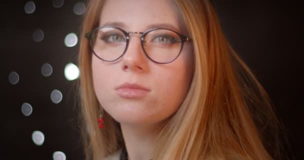 Profil lő szőke modell szemüveg fényes make-up fordul kamera figyel komolyan bokeh háttér. — Stock videók