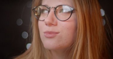 Parlak makyaj gözlük ile Blonde modeli gülümseyerek ve bokeh arka planda kamera ile flört.