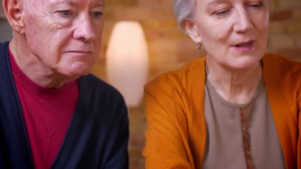 Retrato de close-up de cônjuges caucasianos de cabelos grisalhos seniores conversando uns com os outros alegremente . — Vídeo de Stock