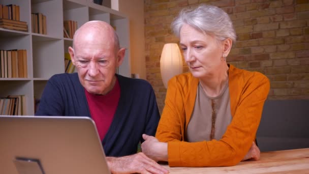 Portret dwóch seniorów szaro-włosach kaukaski małżonkowie rozmawiając w videochat pieszczoty nawzajem czuła w biurze. — Wideo stockowe