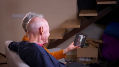 Üst düzey gri saçlı beyaz çiftin, arkadaşlarıyla telefonda görüntülü görüşme yaptığı profil fotoğrafı.