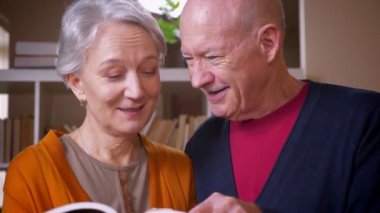Tv'de üst düzey kafkas çift birlikte özenli olmak ve kütüphane ile ilgilenen kitap okuma.
