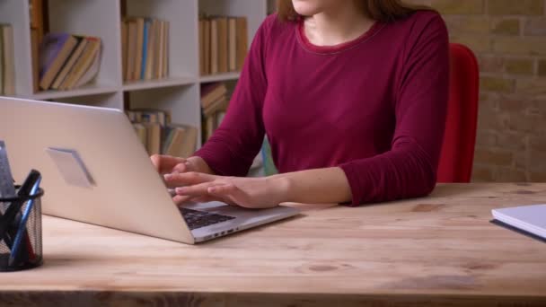 Slide atirar de baixo para cima da jovem mulher de negócios morena trabalha com laptop estar atento no escritório . — Vídeo de Stock