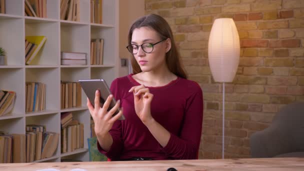 Mulher de negócios bonita em óculos mostra alegre tela verde vertical de tablet para recomendar o aplicativo no escritório . — Vídeo de Stock