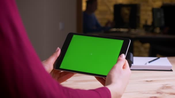 Női kéz tartó vízszintes tabletta zöld chroma képernyőn hivatalban. — Stock videók