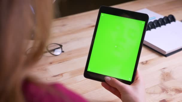 Vrouwelijke Kaukasische handen houden verticaal tablet met groene Chroma scherm op Office achtergrond. — Stockvideo