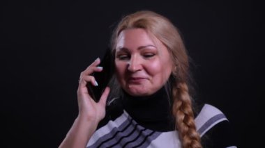 Siyah üzerine izole edilmiş arka planlı bir telefon görüşmesi olan orta yaşlı beyaz kadın closeup portre