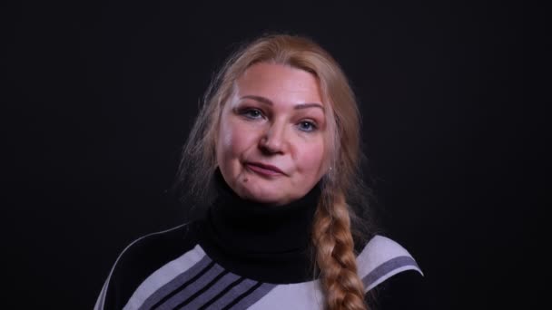 Blízký portrét kavkazské samice středního věku, která se dívá na kameru rozzlobená na pozadí izolovaná na černém — Stock video