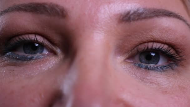 Съемка крупным планом стареющего белого женского лица с глазами, смотрящими в камеру — стоковое видео