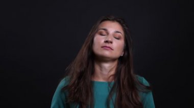 Siyah izole arka plan ile kamera bakarak rahatsız ve rahatsız olan genç güzel esmer kadın Closeup portre