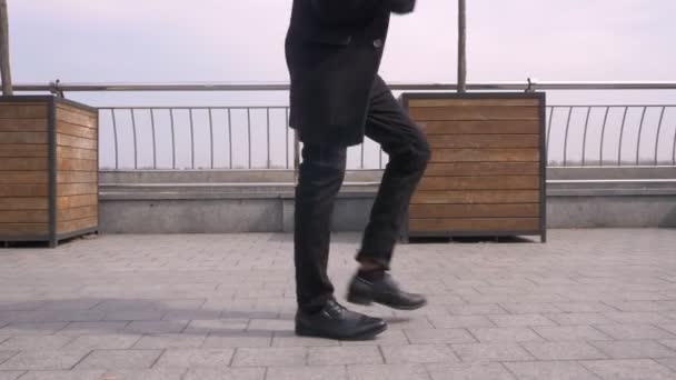 Portrait rapproché d'un jeune homme d'affaires afro-américain séduisant marchant et dansant souriant joyeusement dans la rue au bord de la rivière dans la ville urbaine — Video