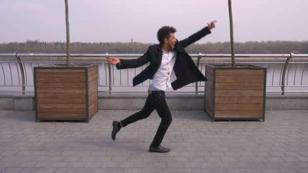 Closeup portrait of young happy attractive african american businessman dancing and making shuffle moves happily on the street in the urban city — Stock Video