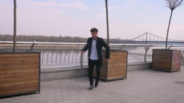 Genç çekici Afro-Amerikan işadamı nın kameraya bakarak dans eden ve şehir şehrinde sokakta neşeyle gülümseyen yakın çekim portresi