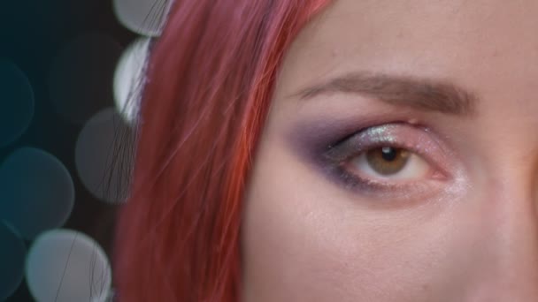 Κοντινό πλάνο μισό πρόσωπο πορτρέτο των νεαρών ελκυστική γυναίκα με κόκκινα βαμμένα μαλλιά κοιτάζοντας την κάμερα — Αρχείο Βίντεο