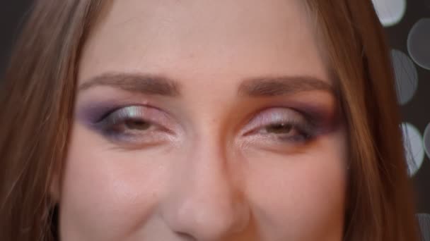 Closeup retrato de jovem muito caucasiano fêmea com olhos olhando para câmera com fundo bokeh — Vídeo de Stock