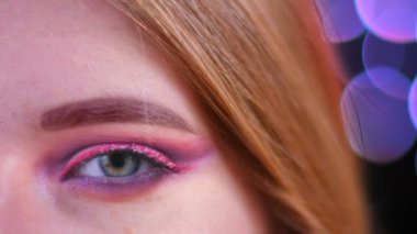 Arka planda bokeh ışıkları ile kamera bakarak pembe güzel pembe glitter makyaj ile genç çekici kafkas kadın Closeup yarım yüz çekimi