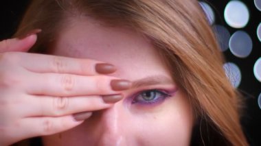 Genç çekici beyaz kadın yarım uygulamalı glitter makyaj ortaya çıkarmak closeup çekim kamera düz bakarak