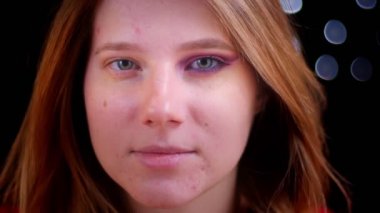 Genç çekici beyaz kadın yarım uygulamalı makyaj ortaya çıkarmak closeup çekim kamera düz bakarak