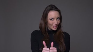 Pretty kadın jestleri thumb-up işareti gibi göstermek ve saygı gri arka plan üzerinde izole.