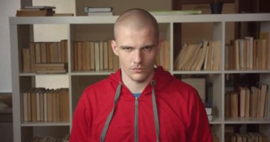 Üniversite Kütüphanesi kapalı kamera bakarak genç çekici beyaz erkek öğrencinin kapatmak portre