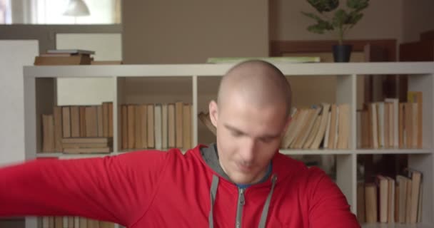 Primer plano retrato de joven atractivo caucásico estudiante masculino dabbing con confianza mirando la cámara en la biblioteca de la universidad en el interior — Vídeos de Stock