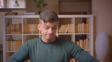 Kütüphanede başarıelde etmiş genç erkek öğrenci dublaj portresi.