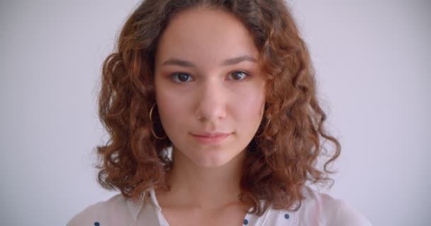 Close-up tiro de jovem atraente longo cabelo encaracolado caucasiano fêmea sorrindo alegremente olhando para a câmera com fundo isolado no branco — Vídeo de Stock