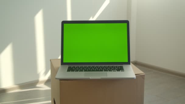 Tiro de close-up de laptop com tela verde que coloca na caixa no escritório dentro de casa — Vídeo de Stock