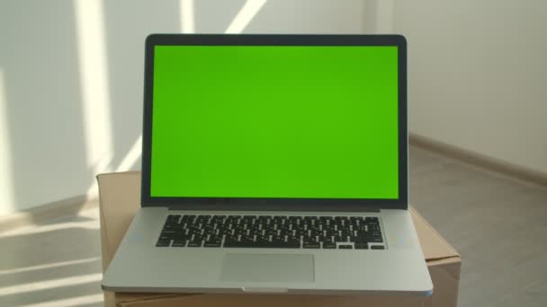 Closeup shoot of laptop with green chroma screen laying on the box in the office indoors — Stock Video