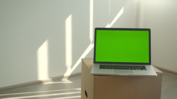 Disparo de primer plano de la computadora portátil con pantalla de clave de croma verde colocada en la caja en la oficina en el interior — Vídeos de Stock