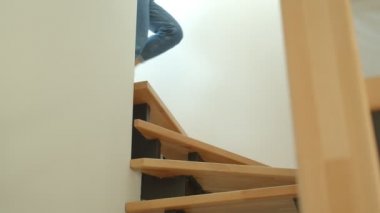 Rahat bir dairede mutlu bir şekilde alt katta çalışan kot pantolon ve spor ayakkabı genç sevimli kadın bacaklar Closeup ateş